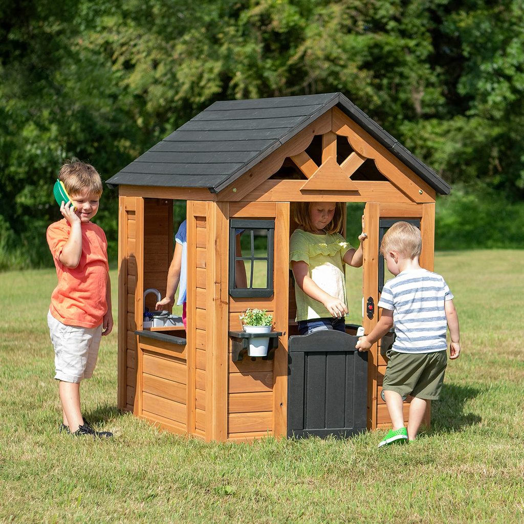 Backyard Discovery Sweetwater wooden playhouse with windows, half door, snack bar window, and outdoor play kitchen setup
